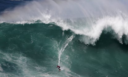 El español Axi Muniain surfea una ola gigante en la playa Norte de Nararé (Portugal), el 18 de abril de 2018.