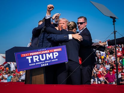 Miembros del servicio secreto rodean a Donald Trump, con el puño en alto, después de que recibiera un disparo durante un mitin en Butler, el 13 de julio de 2024.