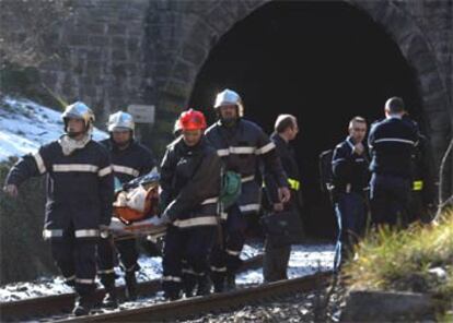 Los servicios de rescate sacan en camilla a una de las víctimas del interior del túnel.