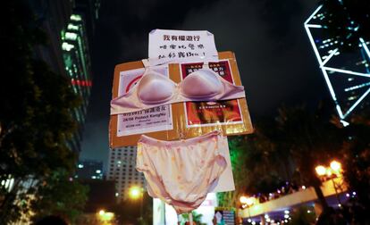 Una pancarta con ropa interior femenina en la que se lee: "No quiero que la policía se lleve toda mi ropa, incluido mi sostén", se levanta durante una manifestación en contra del presunto acoso sexual de la policía a un manifestante detenido, en Hong Kong (China).