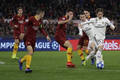 El centrocampista croata del Real Madrid Luka Modric controla el balón ante varios jugadores de la Roma, en una acción del partido.