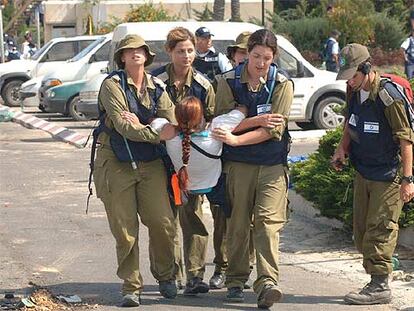 Mujeres soldado israelíes desalojan a una colona judía de un asentamiento del sector de Gush Katif, en Gaza.