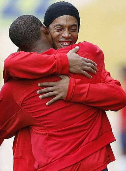 Eto&#39;o, de espaldas, se abraza a Ronaldinho ayer en el entrenamiento.
