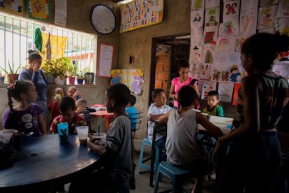 Crianças de recursos limitados almoçam em uma sala de jantar comunitária do programa "Caracas Mi Convive", no bairro de Carapita, em Caracas, Venezuela. Essas crianças, em sua maioria, ocupam espaços públicos no leste de Caracas, onde, além de implorar, criaram um sistema elaborado para sobreviver.