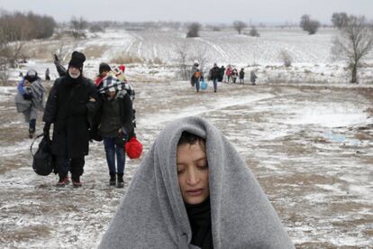 Un grupo de migrantes camina por un campo helado después de cruzar la frontera de Macedonia, cerca de Miratovac.