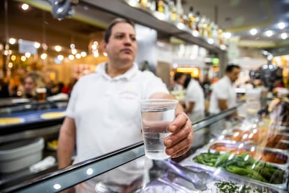 Un camarero sirve un vaso de agua  en un bar cerca de la Plaza Mayor, en Madrid. 