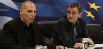 El saliente ministro griego de finanzas Yanis Varufakis habla junto al nuevo ministro Euclides Tsakalotos.