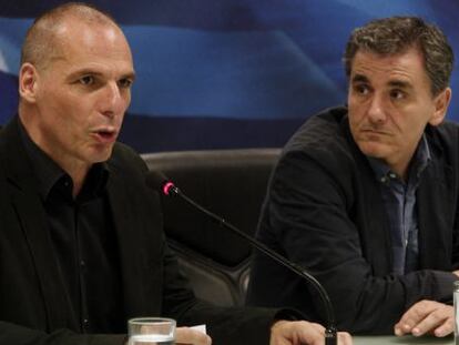 El saliente ministro griego de finanzas Yanis Varufakis habla junto al nuevo ministro Euclides Tsakalotos.