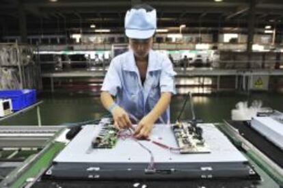 Una operaria china trabaja en una l&iacute;nea de ensamblaje de televisores en una f&aacute;brica de Shenyang, en la provincia de Liaoning (China).