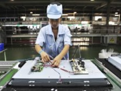 Una operaria china trabaja en una l&iacute;nea de ensamblaje de televisores en una f&aacute;brica de Shenyang, en la provincia de Liaoning (China).