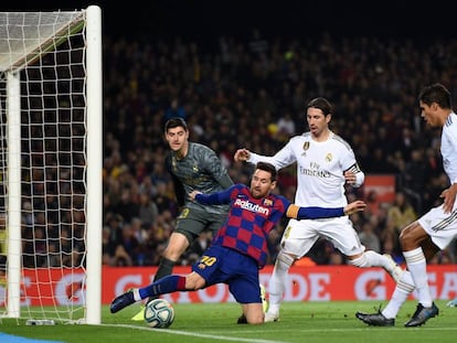 Messi trata de retener el balón ante el Madrid.