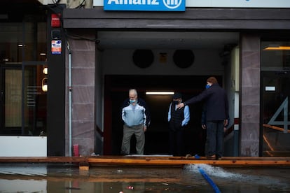 Varios hombres observan una calle inundada en Tudela (Navarra), este lunes. La crecida del Ebro ha provocado que en Tudela se hayan inundado por filtración, a través de la red de alcantarillado, zonas bajas del casco antiguo próximas al río. No se han registrado incidencias más allá de las normales en esta situación de excepcionalidad, si bien se encuentran anegados garajes, bajeras y algunos comercios.