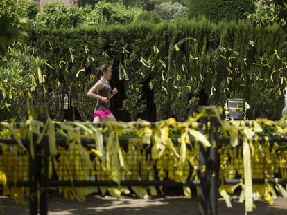 Una jove corre en una zona plena de llaços grocs, al parc de la Ciutadella.