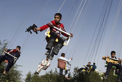 20 de septiembre de 2009. Un niño afgano con una pistola en la mano, disfruta de una atracción durante la celebración de la fiesta de Eid al-Fitr, en Kabul, Afganistán.