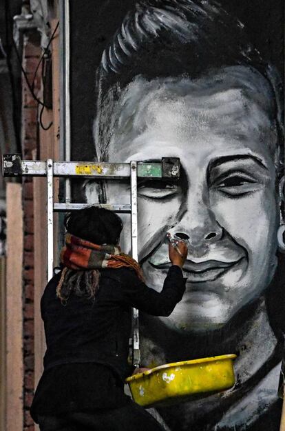 Una estudiante pinta un mural que representa al joven manifestante muerto por un disparo de un miembro del Escuadrón Antidisturbios Móvil (ESMAD) durante una protesta contra el Gobierno colombiano.