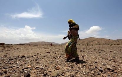 Una mujer, desplazada interna, lleva a cuestas a su hijo mientras espera a que llegue ayuda humanitaria en Hariirad, Somaliland, el pasado 16 de abril. En el Cuerno de África, millones de personas han sido golpeadas por la sequía que ha causado el fenómeno climático 'El Niño'. En Somaliland, un territorio situado en la frontera entre Etiopía y Somalia, y en la próxima región de Puntland, 1,7 millones necesitan ayuda urgente, según las Naciones Unidas.