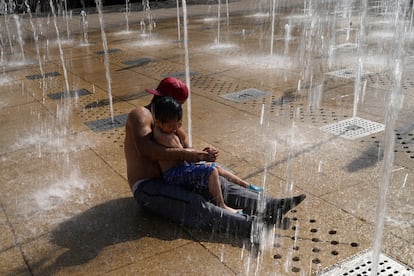 A father and his son cool off in the fountain at the Monument to the Mexican Revolution, in Mexico City, on April 16, 2024.