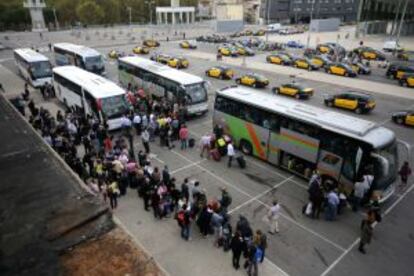 Passatgers esperen per pujar als autocars a l'Estació de Sants.