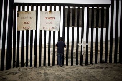 Un hombre en el muro fronterizo entre M&eacute;xico y Estados Unidos, en playas de Tijuana, en 2012.