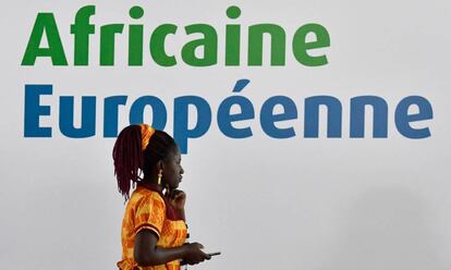 Una mujer, ante el cartel de la cumbre &Aacute;frica-Europa de Costa de Marfil.