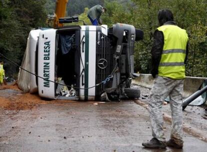 El conductor de un camión observa su vehículo siniestrado en Andoain.