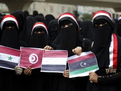 Unas mujeres muestran las banderas de Siria, túnez, Yemen y Libia en una manifestación.