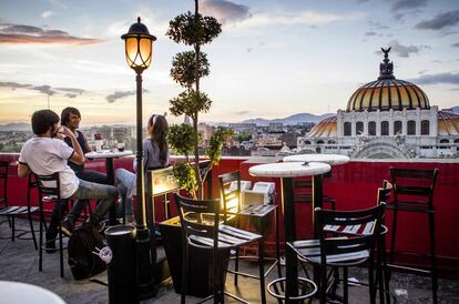 Terraza de un café en Ciudad de México, con el Palacio de Bellas Artes al fondo.