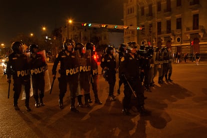 Elementos de la policía antidisturbios impiden el paso de un grupo de manifestantes a una de las avenidas que lleva al palacio de Miraflores, en el centro de Lima, la noche del día 18. 