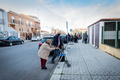 Ana Guijarro, de 74 años, llega al centro de vacunación ayudada por su marido Manuel Retamar, de 79. 