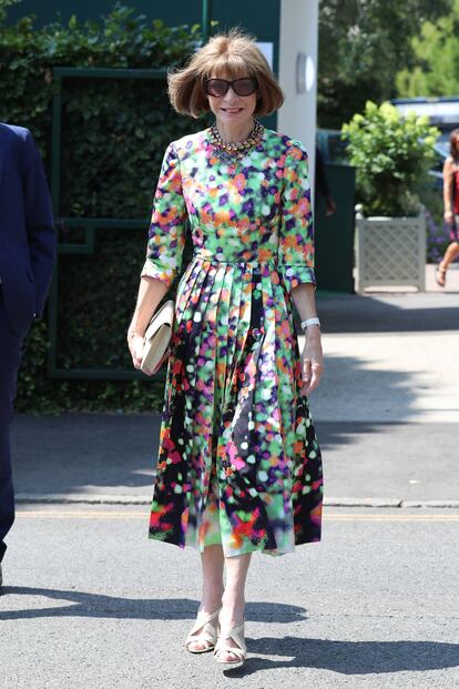 Aquí, Anna lleva un llamativo vestido estampado de falda plisada con sandalias cruzadas y bolso a juego.