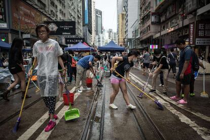 Las disputas se han producido cuando ciudadanos contrarios a la ocupación de la calle comenzaron a desmontar las tiendas y las barricadas de los jóvenes manifestantes en estas dos zonas. En la imagen, jóvenes limpian una de las calles ocupadas en el centro de Hong Kong.