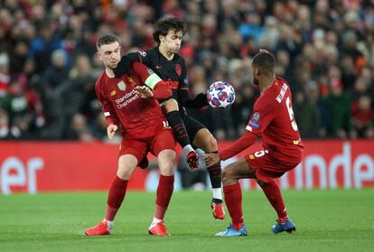 João Félix intenta llevarse el balón ante la oposición de los jugadores del Liverpool Jordan Henderson y Georginio Wijnaldum.