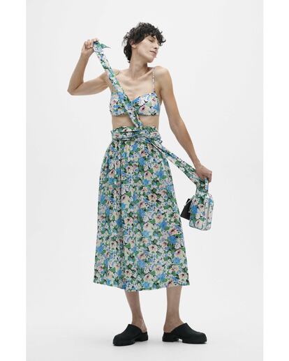 Ganni. La marca danesa es experta en desarrollar estampados sugerentes y explotarlos hasta la saciedad. Para esta primavera, la trama  de Floral Zure Blue se desliza en faldas pareo, pantalones, bikinis y bolsos. Este top bandeau coronado con un escote corazón es la pieza más versátil de su catálogo, que permite combinarlo con todo tipo de prendas inferiores, incluso ejercerá de bañador cuando el calor apriete.