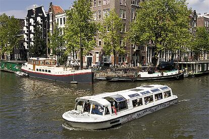 Un barco de turistas navega en el canal de Prinsengracht, en ?msterdam.