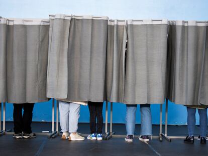 Varias personas ejercen su derecho al voto en el pabellón polideportivo Ames en A Coruña, este domingo.