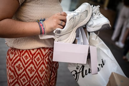 Una chica muestra las zapatillas que se ha comprado.
