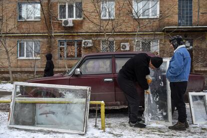 Vecinos arreglan sus ventanas dañadas por una de las explosiones en Kiev esta mañana.