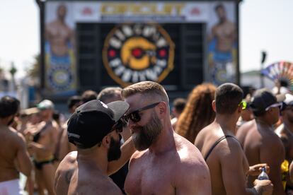 Dos hombres se abrazan en la piscina del parque acuática, durante el festival. 