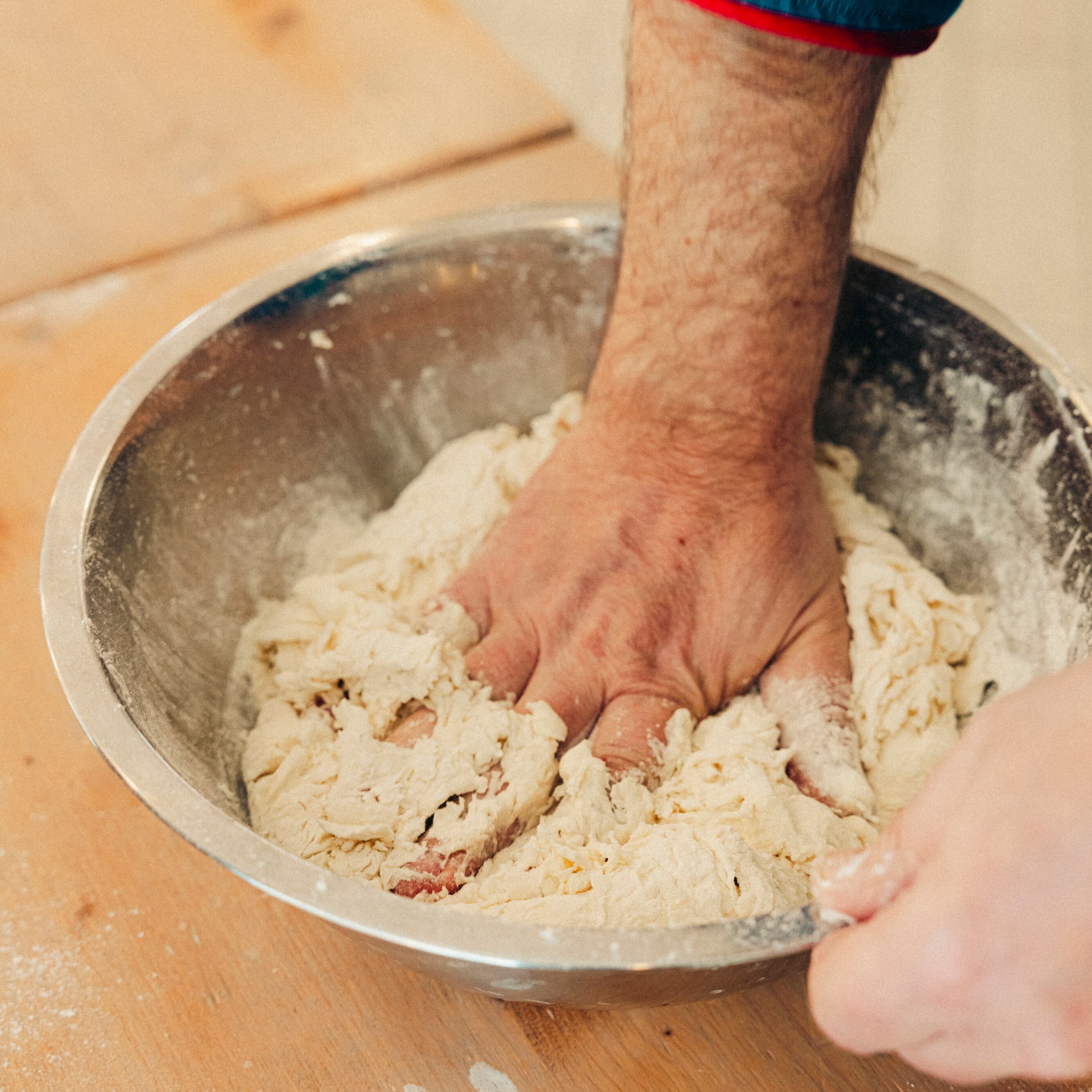 Uno de los maestros de la escuela de la Asociación de la Pizza Napolitana Verdadera comienza la preparación de la masa. La primera parte consiste en mezclar bien la harina, el agua y la levadura