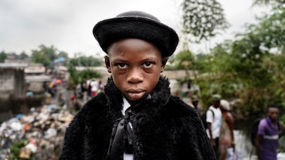 Natan Mahata, 8-year-old school student and sapeur for 3 years, in Kinshasa, 2019.
He wears jacket and hat by Zara, trousers by Place, shirt by Pierre Cardin, suspenders by Boris and shoes by JM Weston.