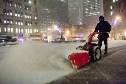 Um homem remove a neve em Manhattan.