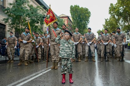 Un niño posa delante de efectivos poco antes del comienzo del desfile. 