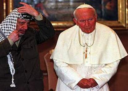 El líder palestino, Yasser Arafat, ajustando su kefiya, durante su encuentro en 1998 con Juan Pablo II, en el Vaticano. (12-6-98)