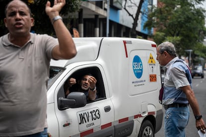 Un conductor discute con un paciente que bloquea la Avenida de las Américas, en protesta por sumar más de 12 horas de espera para recibir sus medicamentos en el dispensario Disfarma.