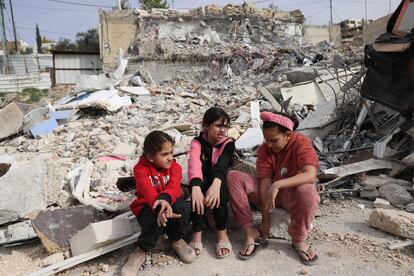 Tres niñas palestinas, sobre los escombros de una casa demolida por 'bulldozers' israelíes en el barrio jerosolimitano de Yabal Mukaber, este domingo.