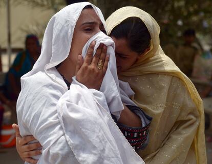 uas mulheres choram a morte de um familiar por conta da forte onda de calor que há quatro dias afeta a província paquistanesa de Sindh, no sul do país. O Governo colocou os hospitais de Karachi, a capital da província, em estado de atenção.