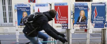 Ciclista passa diante de cartazes de Marion Maréchal em Marselha durante as eleições francesas.