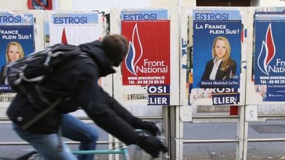 Ciclista passa diante de cartazes de Marion Maréchal em Marselha durante as eleições francesas.