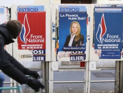 Ciclista passa diante de cartazes de Marion Maréchal em Marselha durante as eleições francesas.