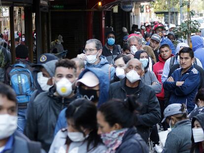 Una cola de desempleados con mascarillas esperan para solicitar el seguro de desempleo en Santiago de Chile.